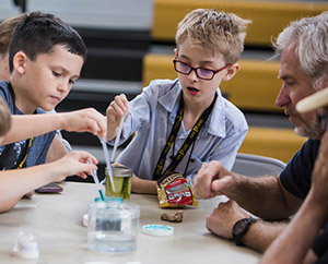 Children doing a science experiment with an older man