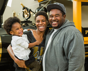 A smiling black family posing in front of the Boilermaker Special